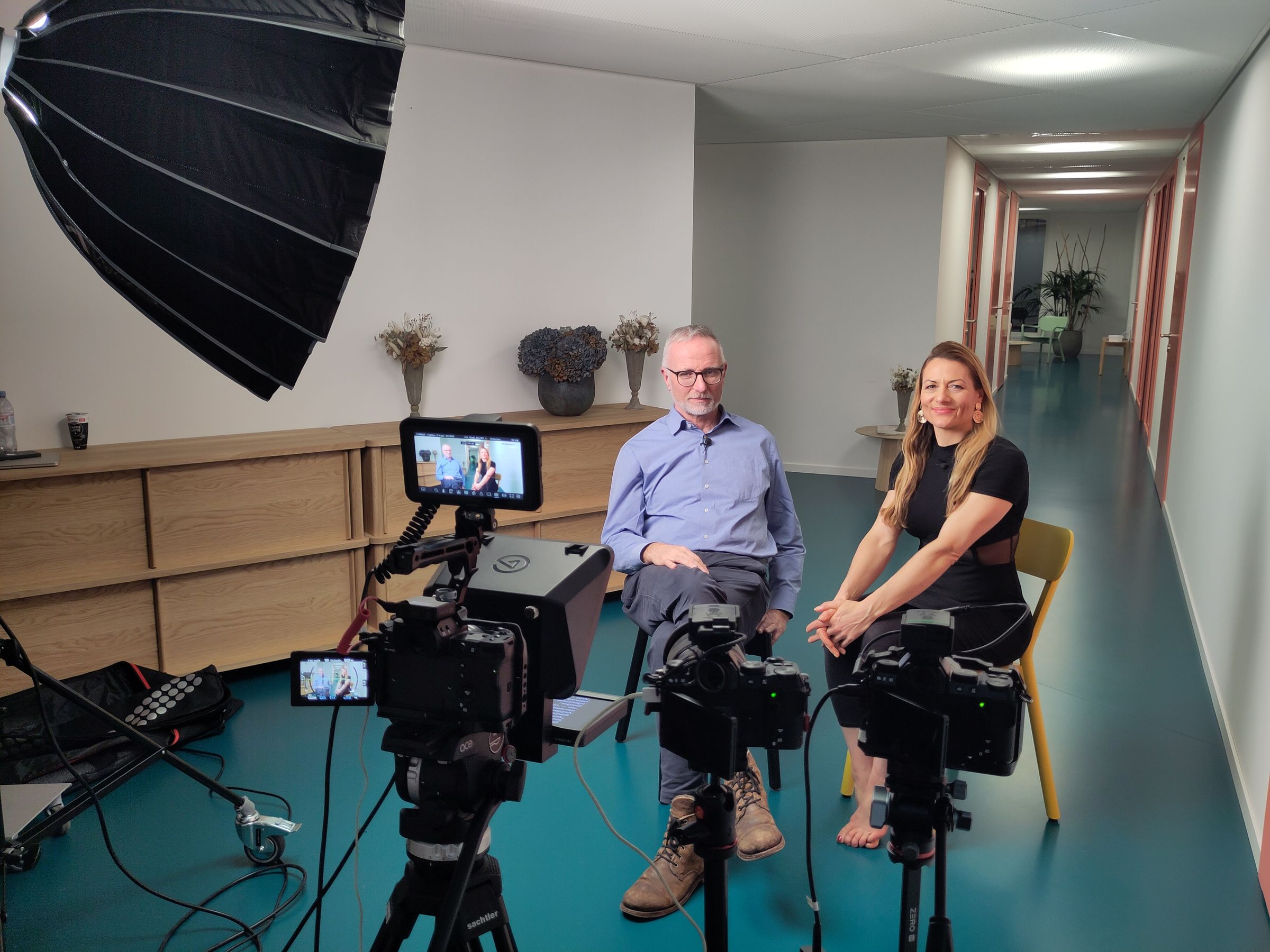 Doppelinterview mit zwei Personen, Kamera und Softbox in einem Büro