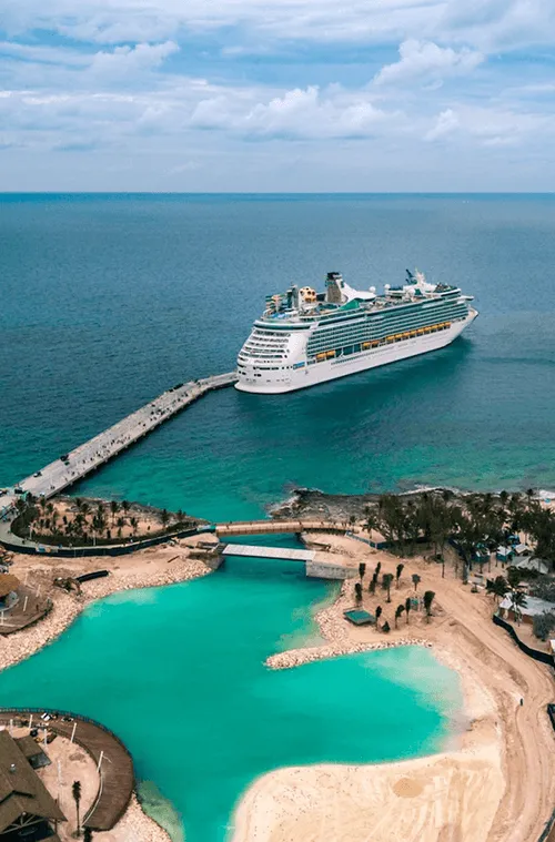 A cruise ship docked at a pier in the ocean.