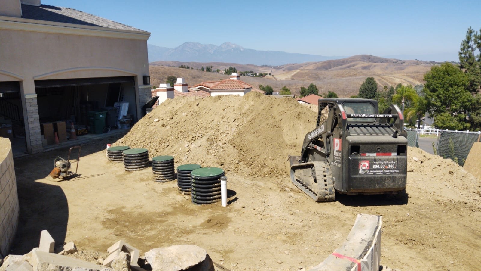 Septic risers on a hillside site with a skid steer