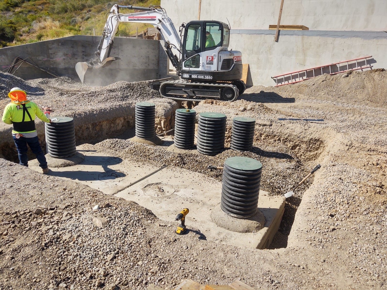 Septic system risers set with an excavator and crew