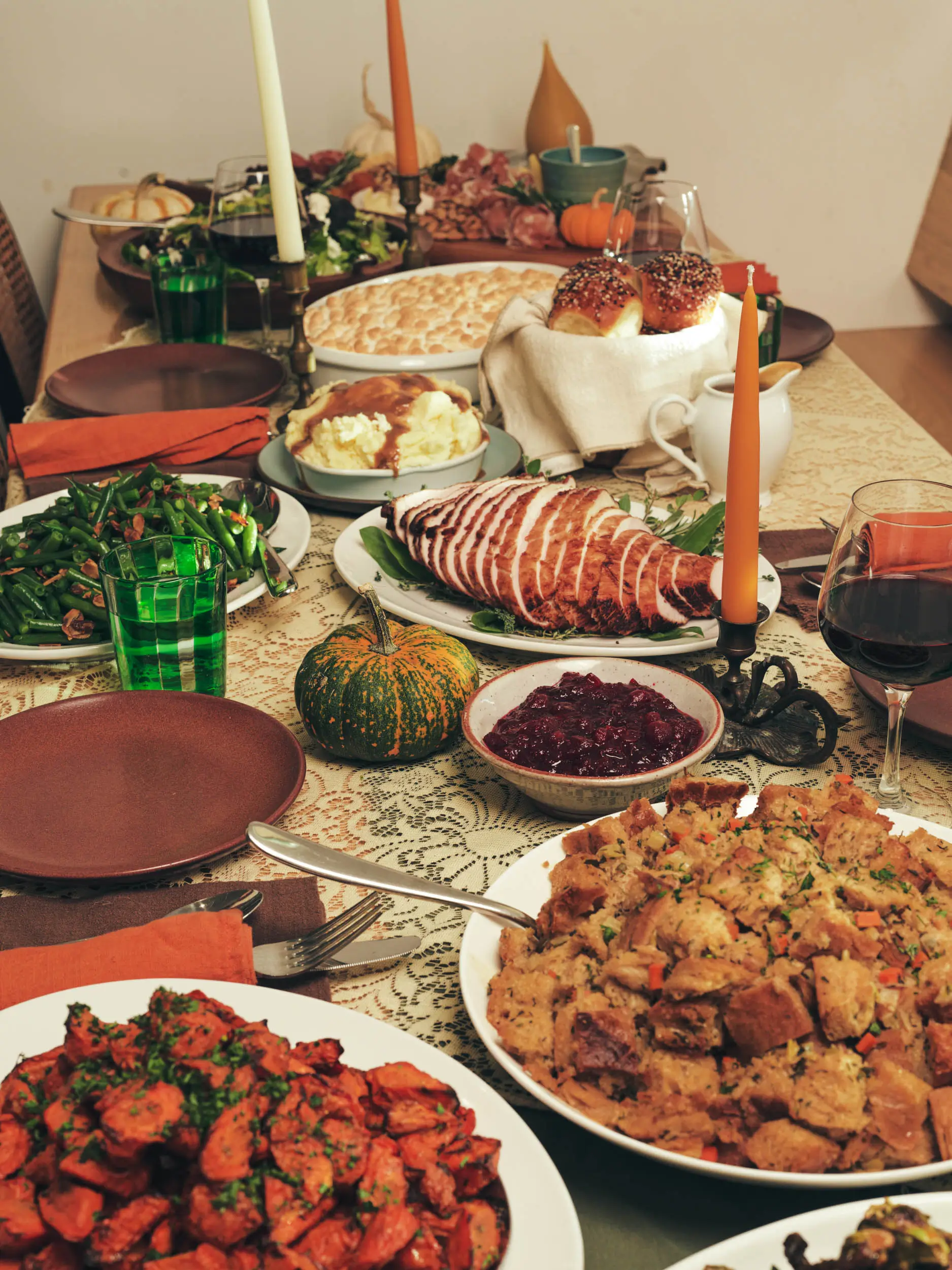 Sliced turkey, stuffing and cranberry sauce on a candlelit table