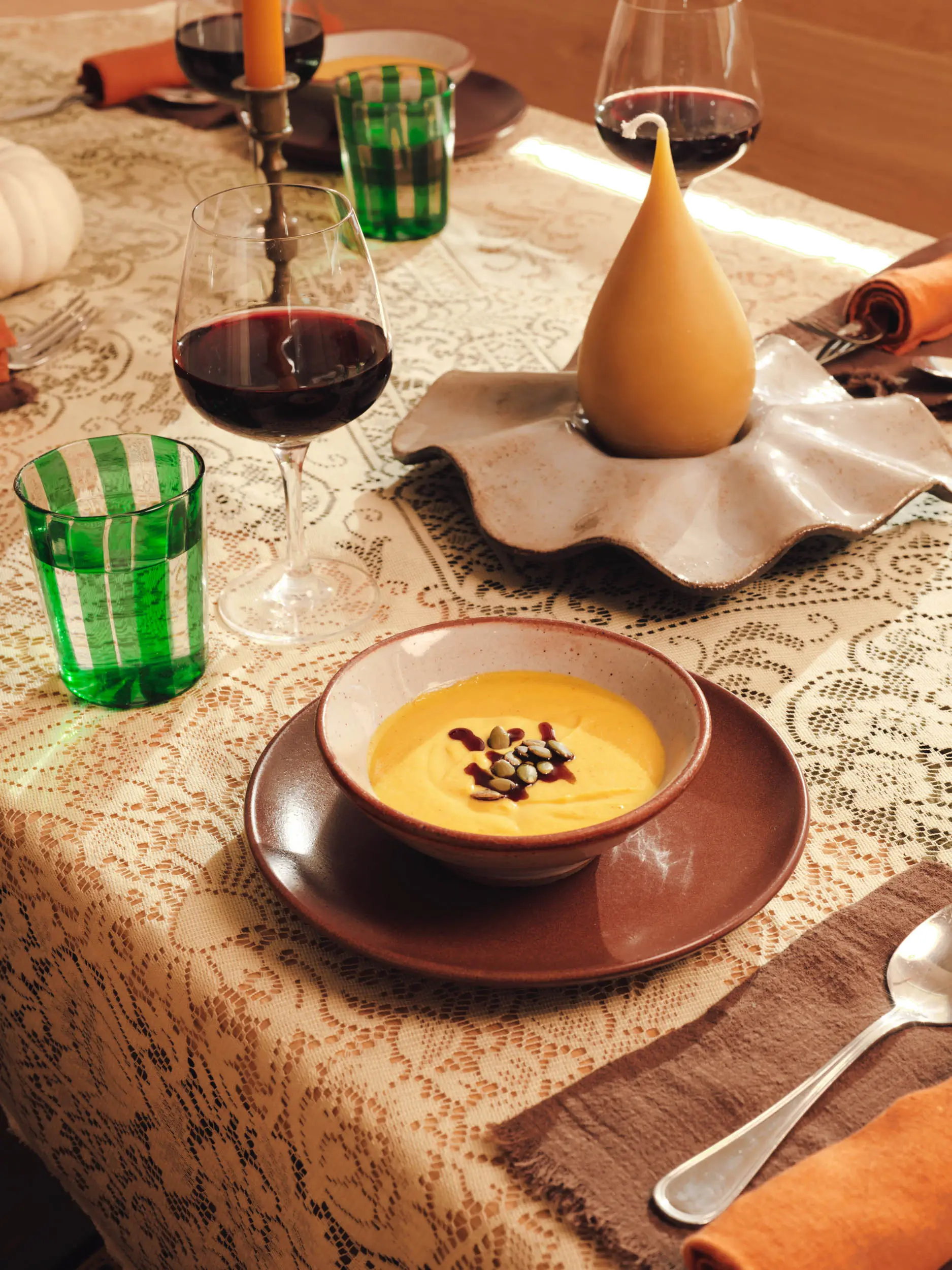 Butternut squash soup with pepitas on a candlelit table