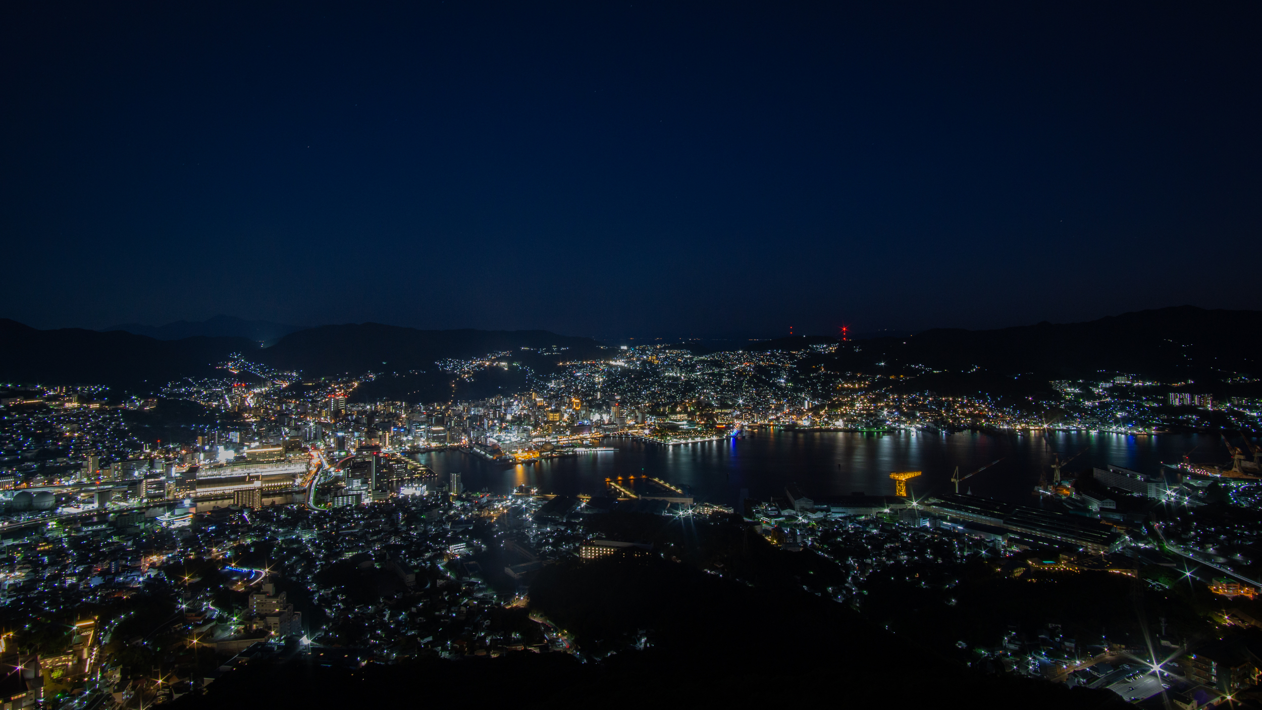 Lichter einer Hafenstadt bei Nacht, von oben gesehen