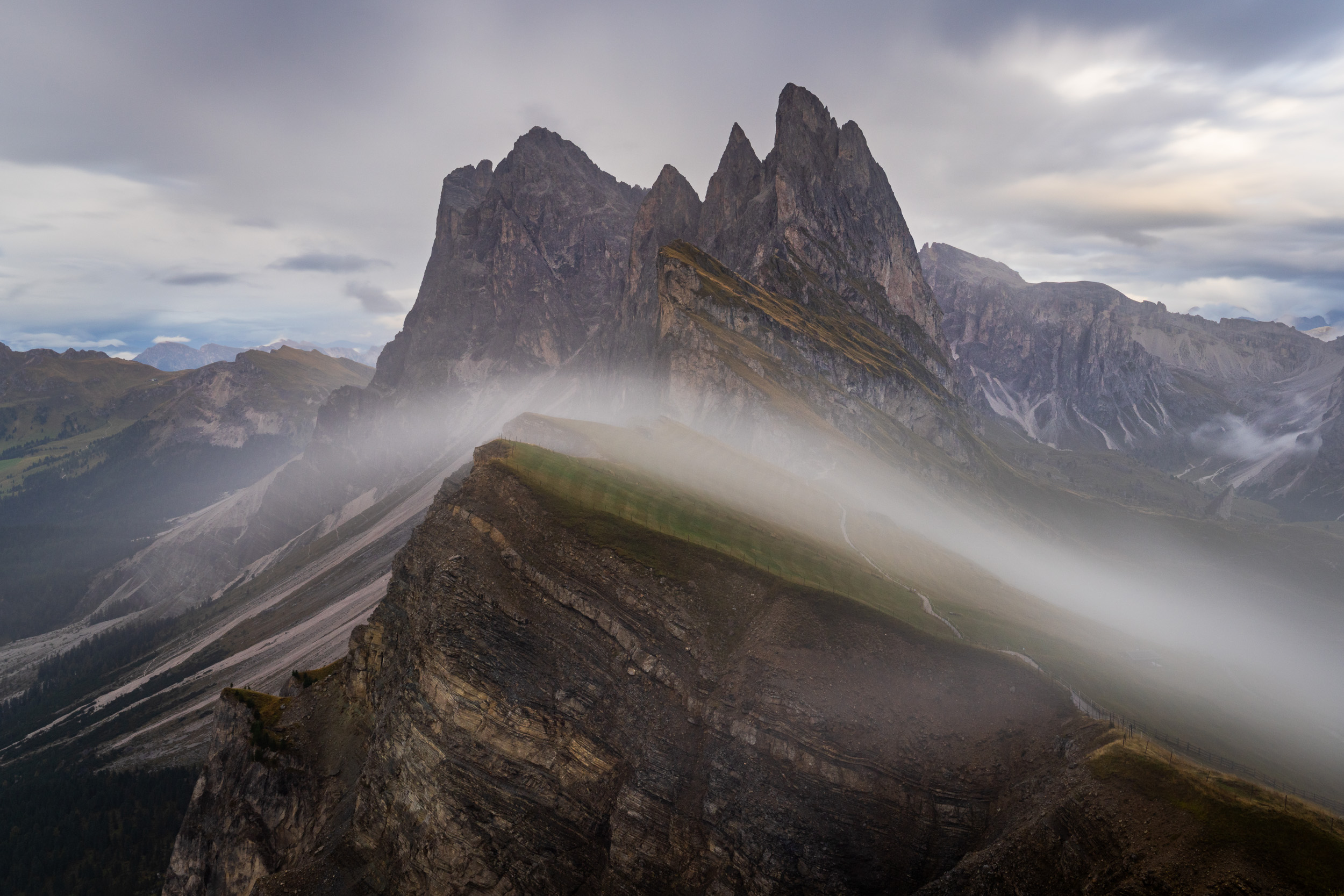 Nebelschwaden ziehen über den Grat der Seceda, dahinter die Geislerspitzen