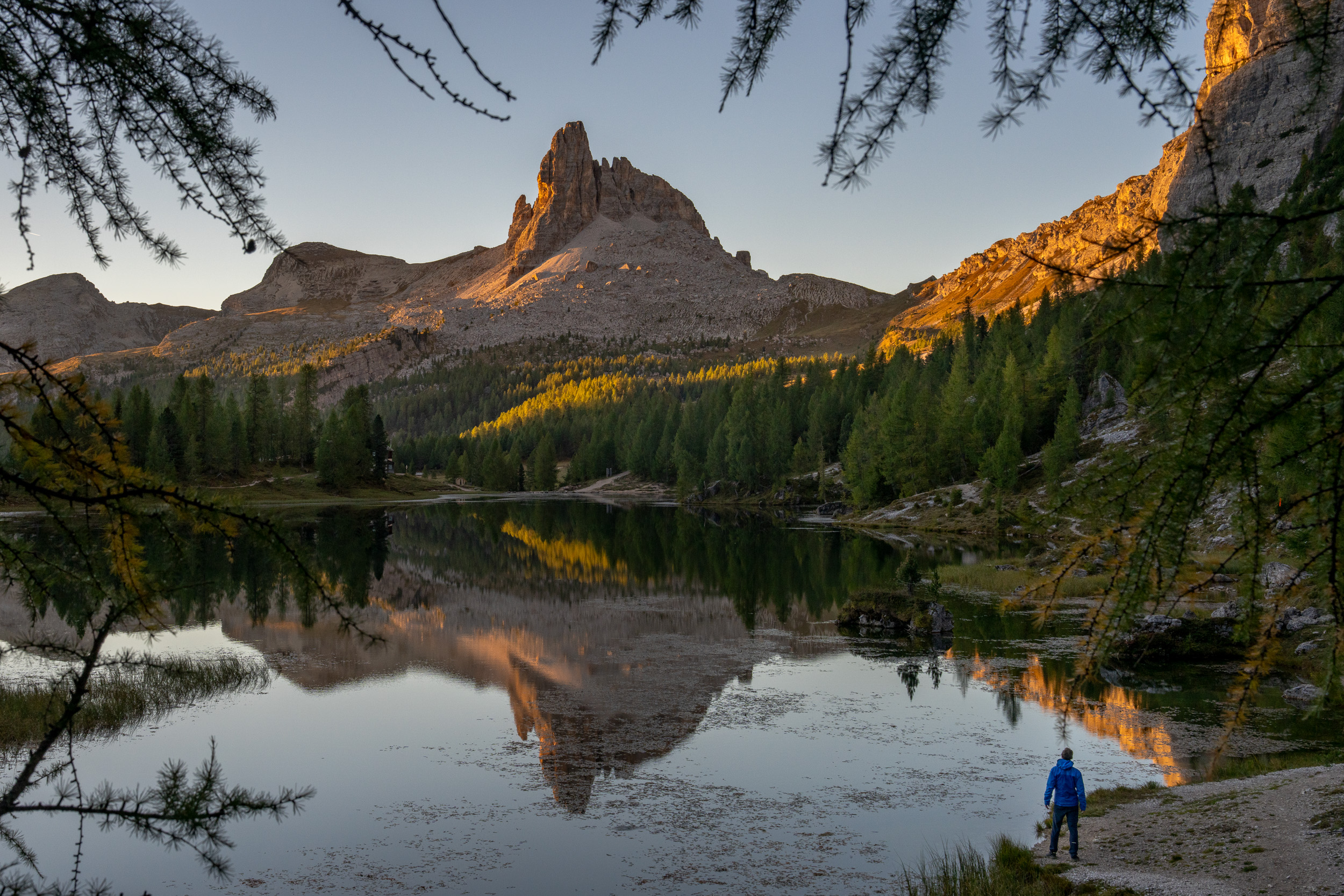 Wanderer am Ufer des Lago Federa, im Wasser spiegelt sich der Becco di Mezzodì