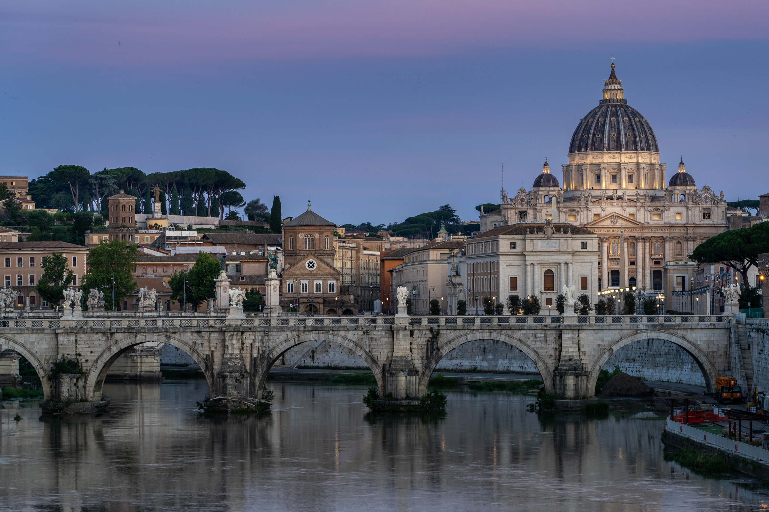 Engelsbrücke und Petersdom in der Morgendämmerung unter rosa Himmel