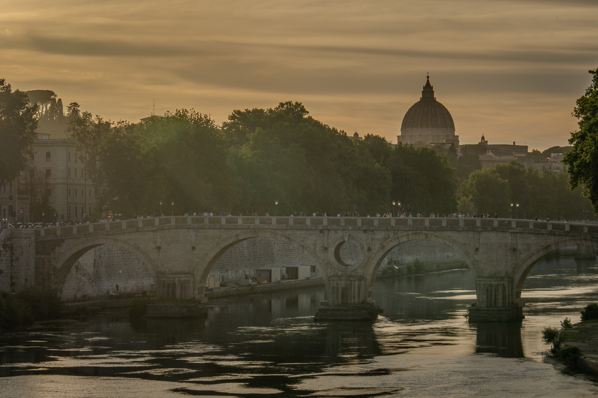 Ponte Sisto über dem Tiber, dahinter die Kuppel des Petersdoms im Abenddunst