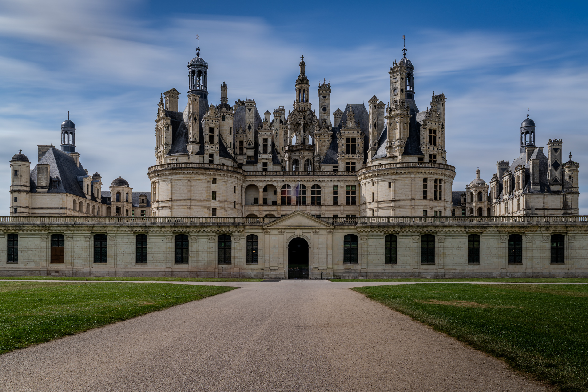 Schloss Chambord am Ende der Zufahrt, darüber Wolken