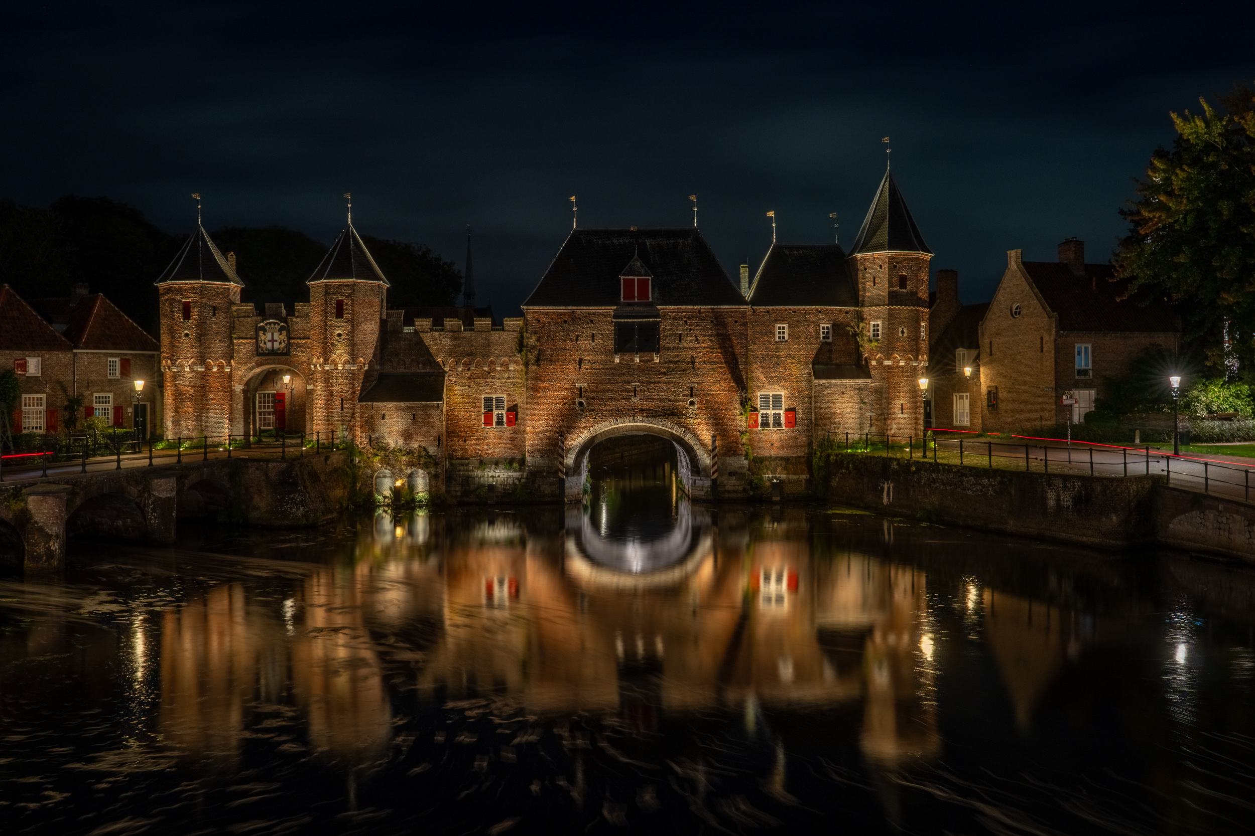 Koppelpoort bei Nacht, gespiegelt im Wasser