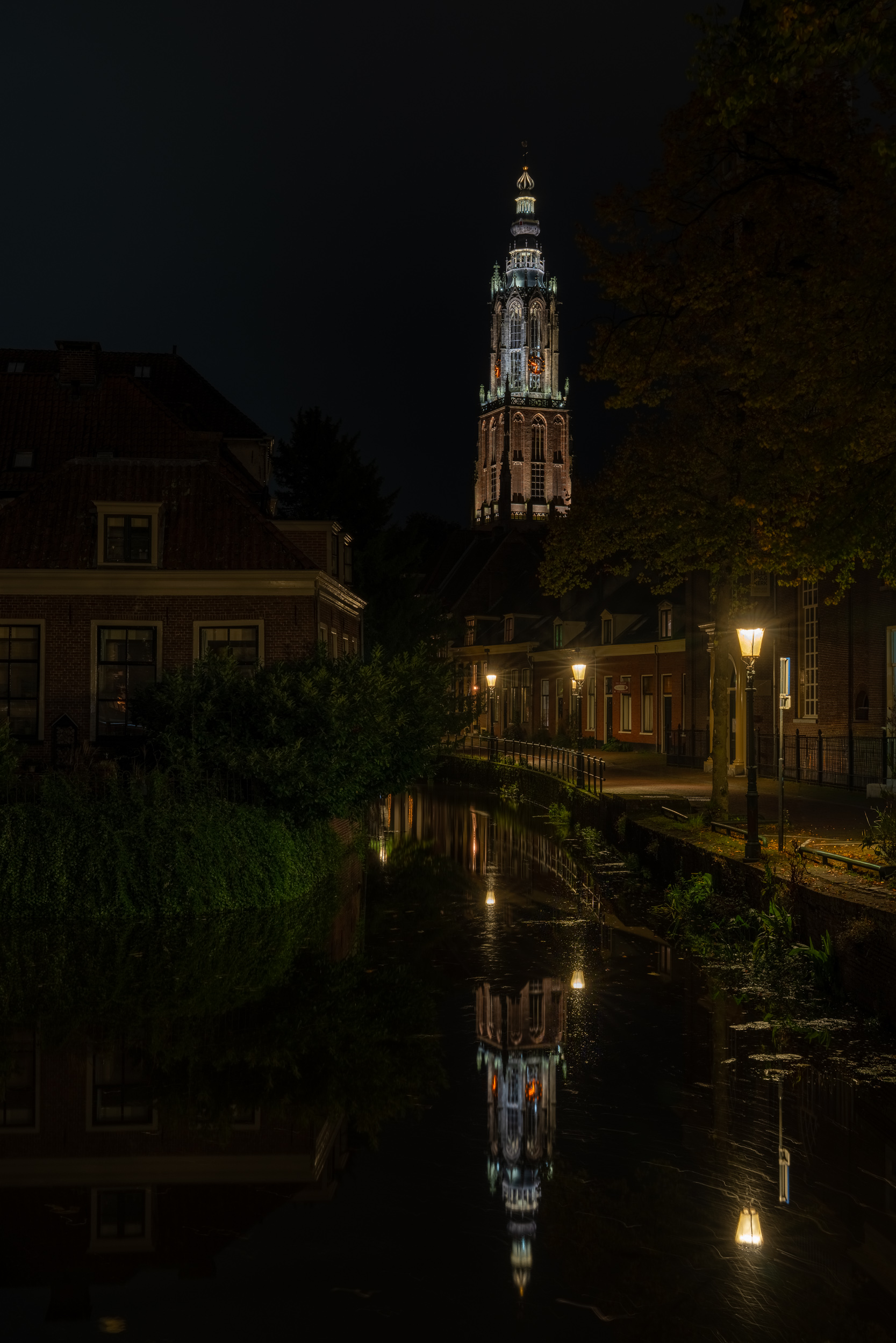 Onze Lieve Vrouwetoren bei Nacht, gespiegelt in einer Gracht