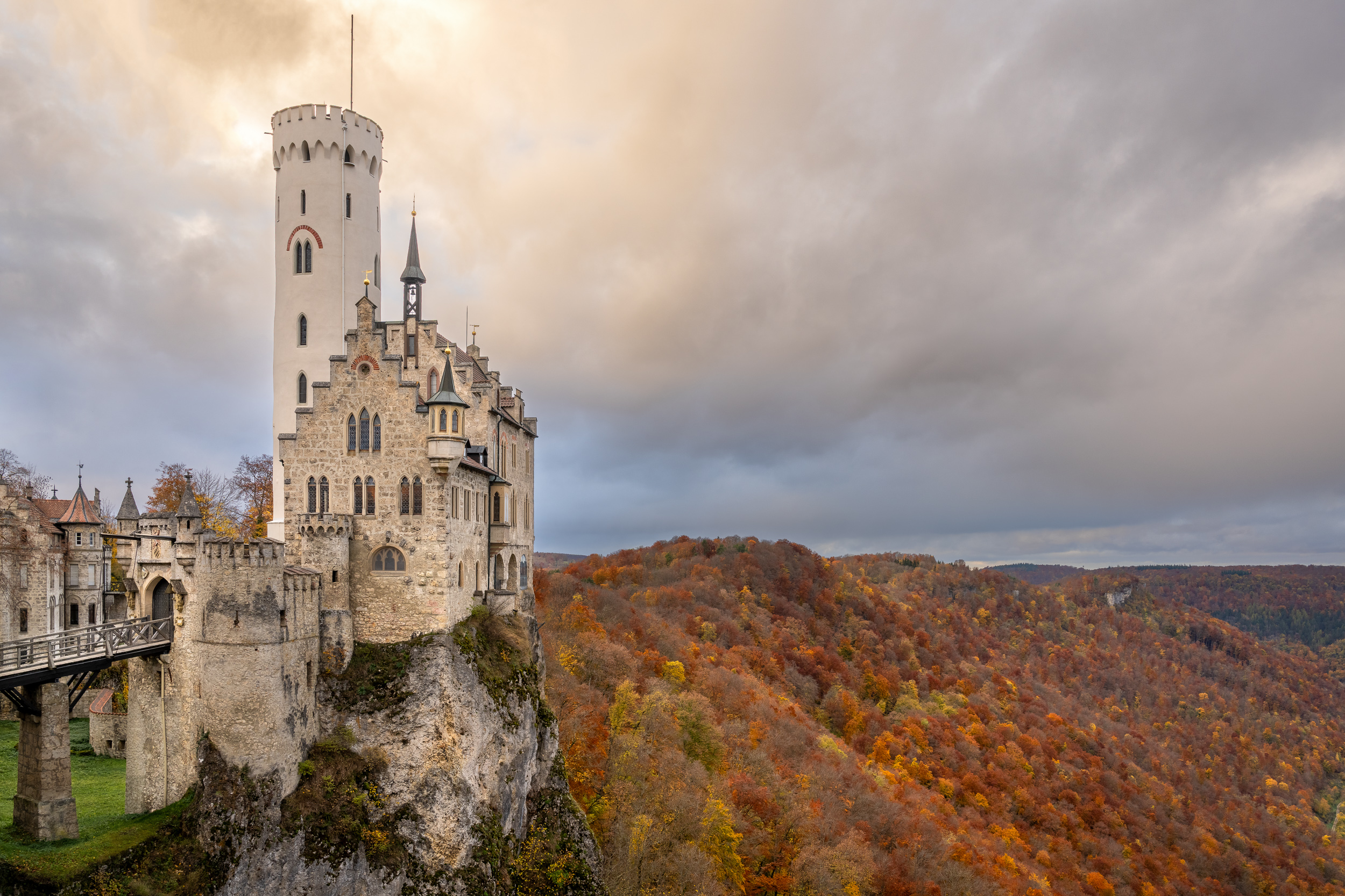 Schloss Lichtenstein auf dem Felsen über herbstlich gefärbtem Wald