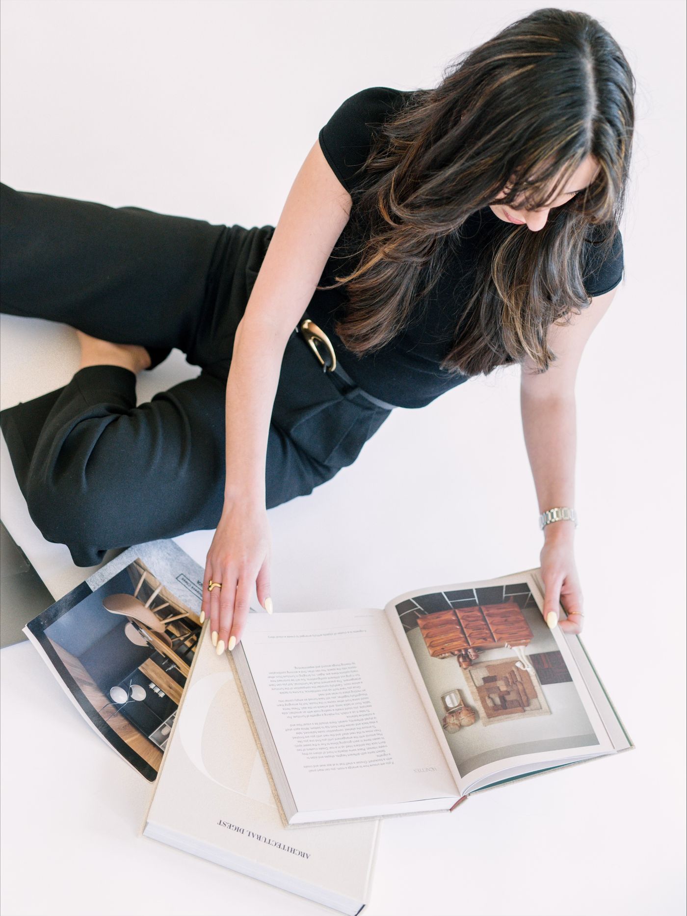 Jessica sitting on the floor, leafing through an interior design book