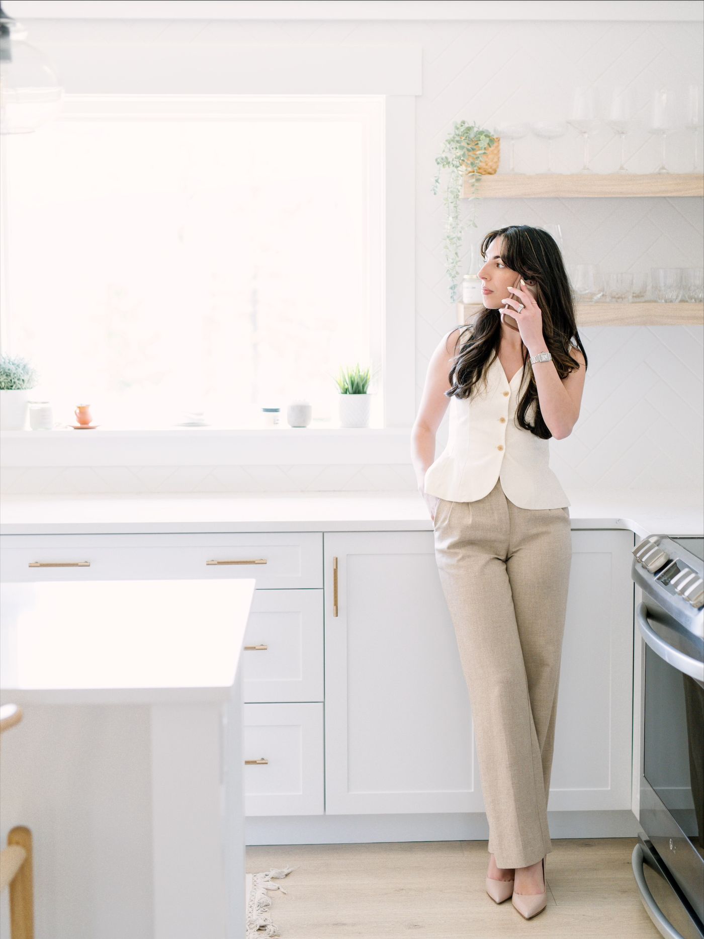 Jessica on the phone by a bright kitchen window