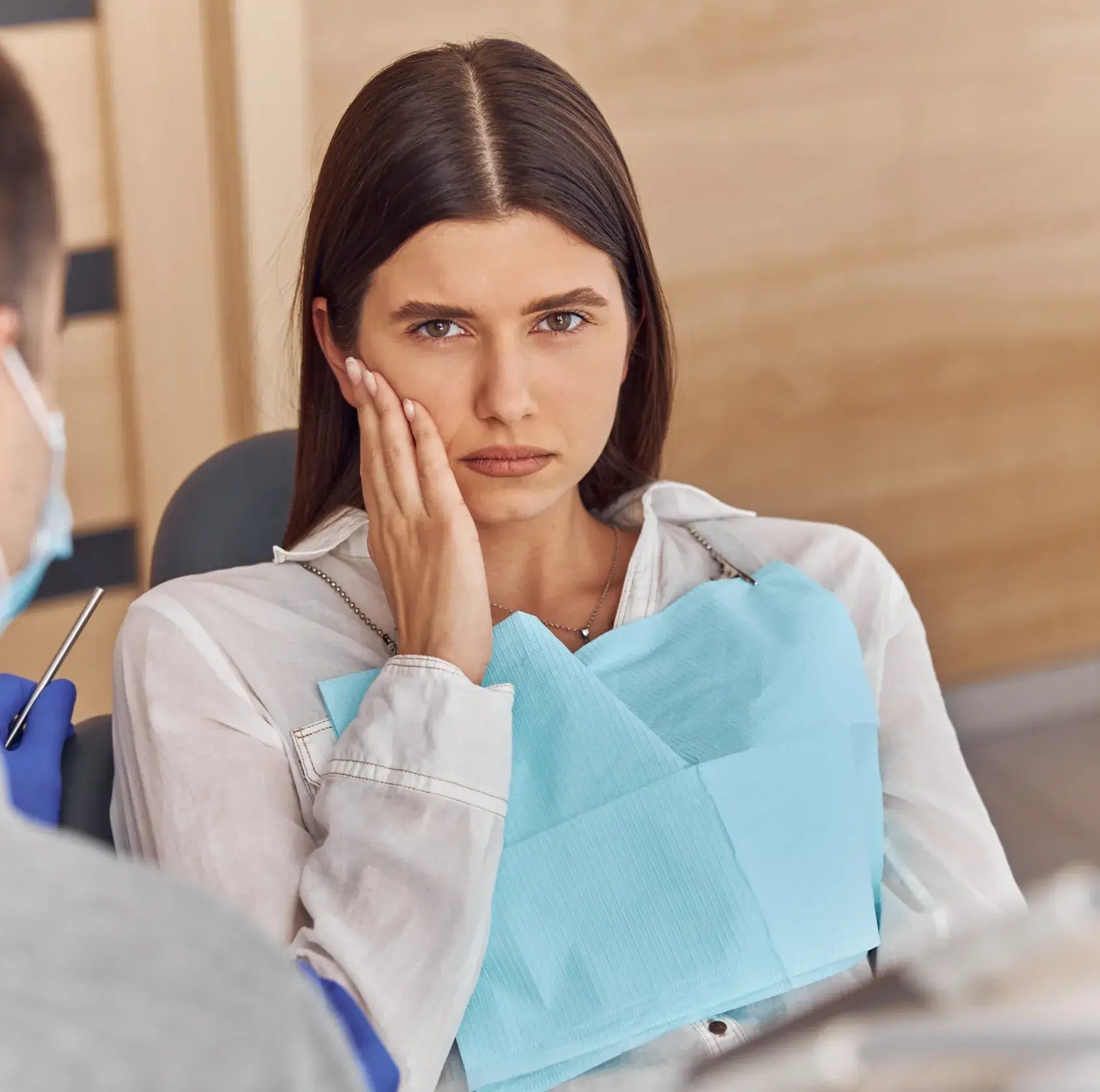 A woman sitting in front of a man in a medical mask.