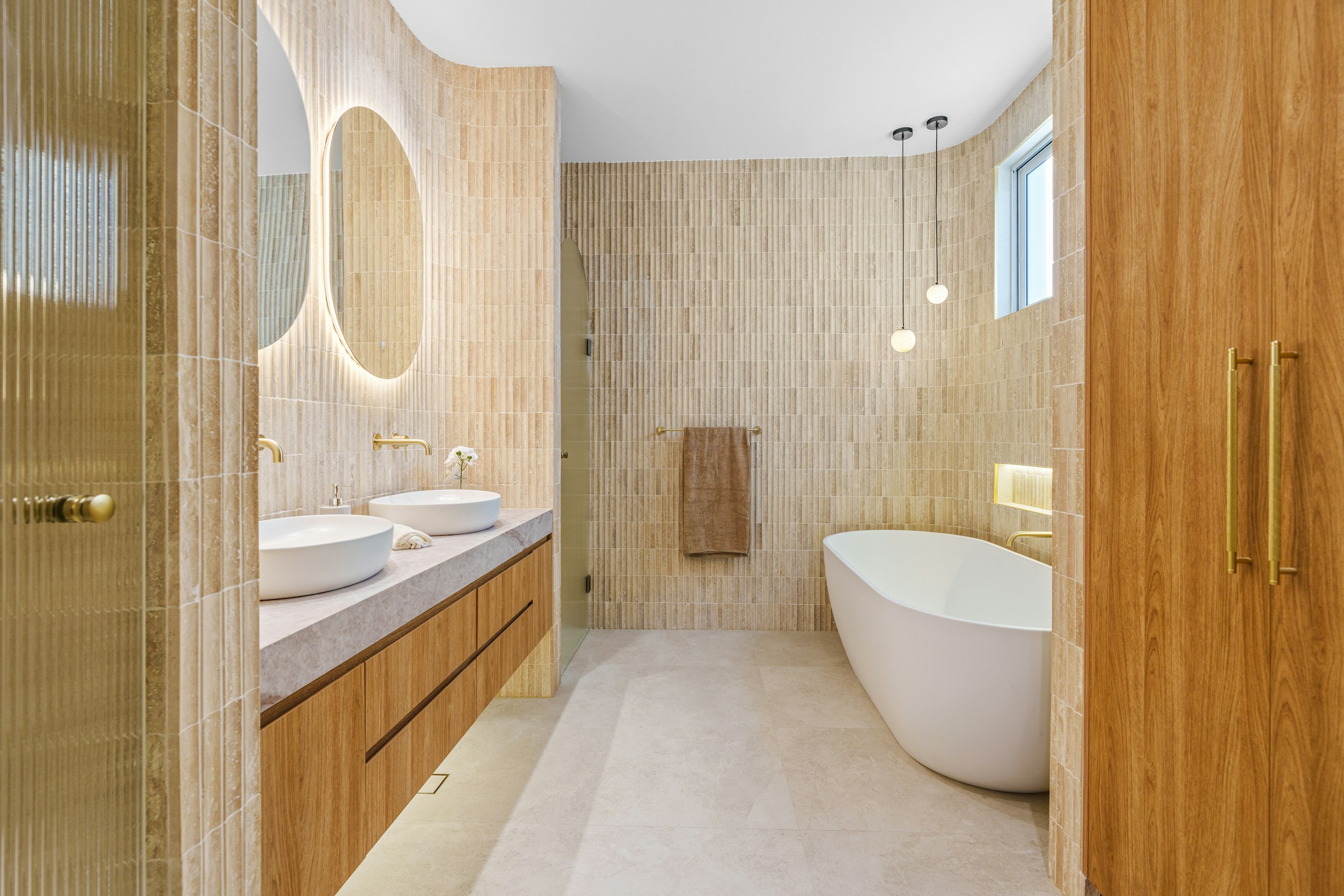 A tiled walk-in shower with a glass panel