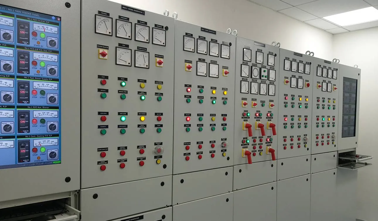 A row of grey switchboard panels with dials, coloured lights and red switches, beside a touch screen of pump controls