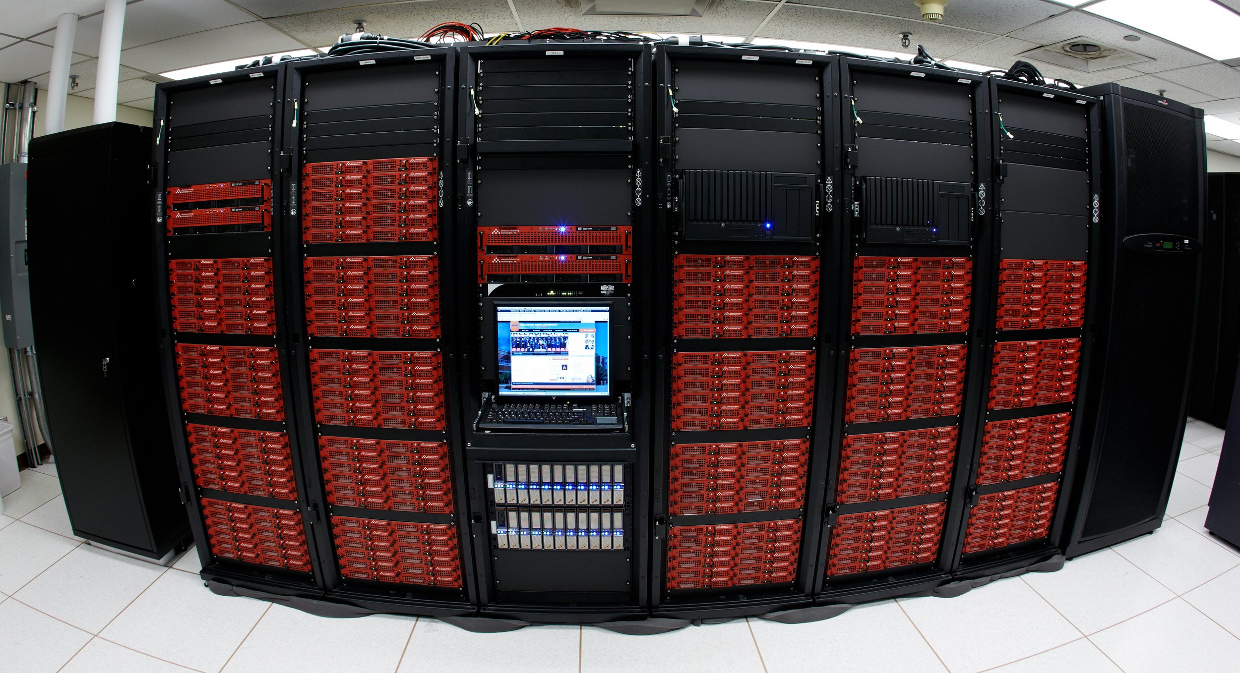 A curved row of Advanced Clustering cluster racks with red server faceplates