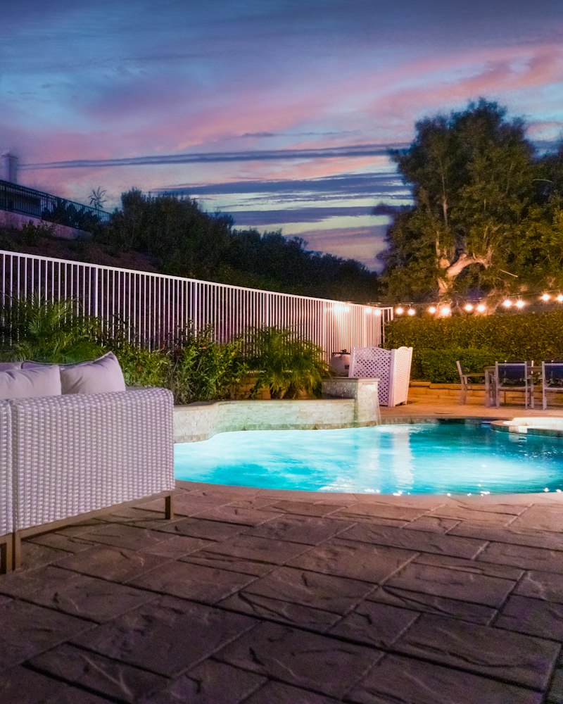 Outdoor lounge with a fireplace at dusk