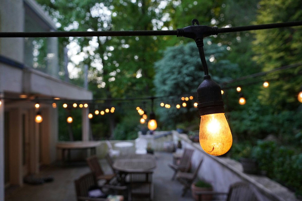 Patio dining area under string lights in the evening