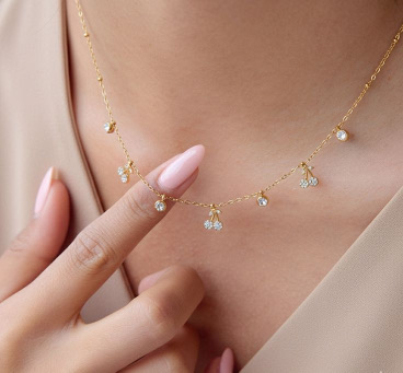Hands touching a fine gold necklace