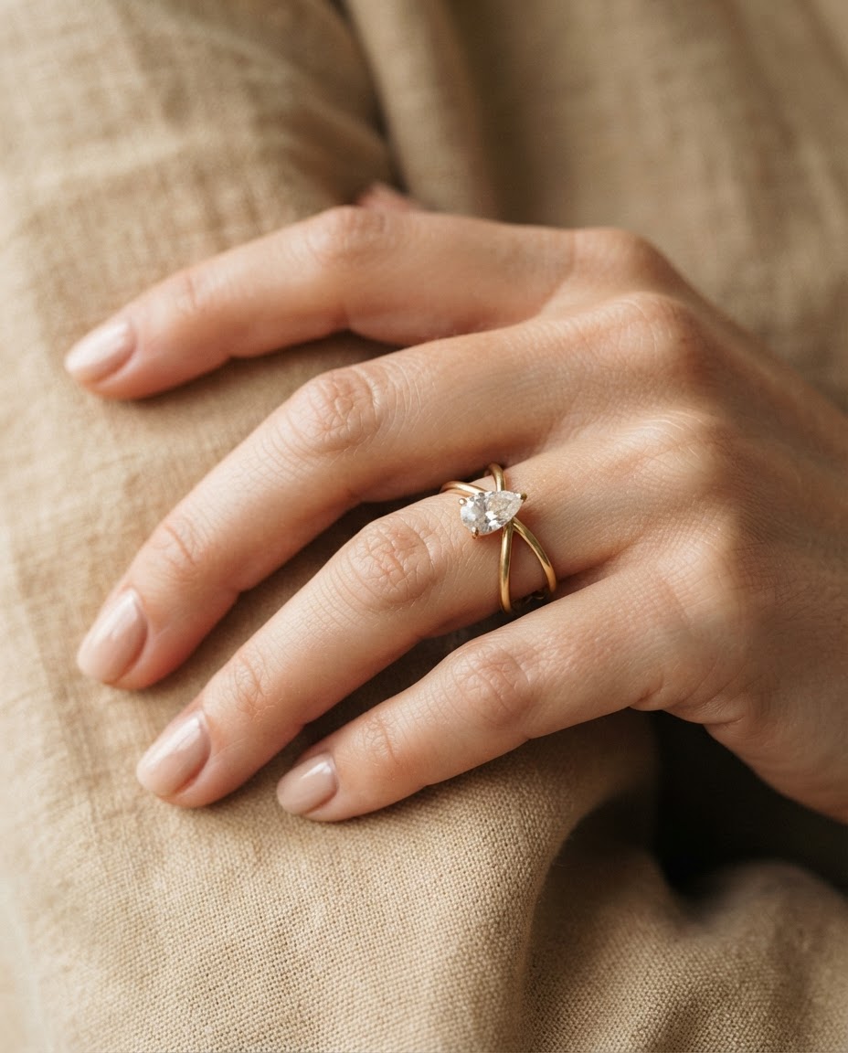 Pear solitaire ring on a finger