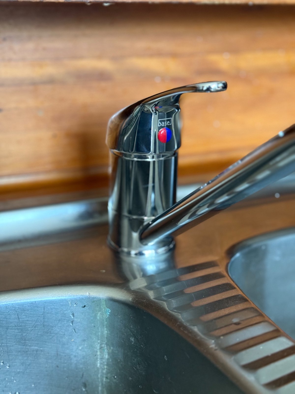 New chrome single-lever mixer tap fitted on a stainless steel kitchen sink