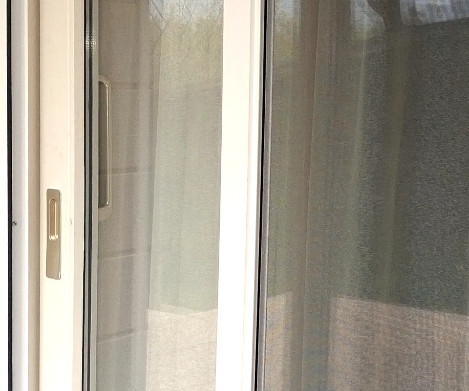 Barre de tirage et poignée d’une moustiquaire latérale enroulable sur une porte-fenêtre à Vétraz-Monthoux