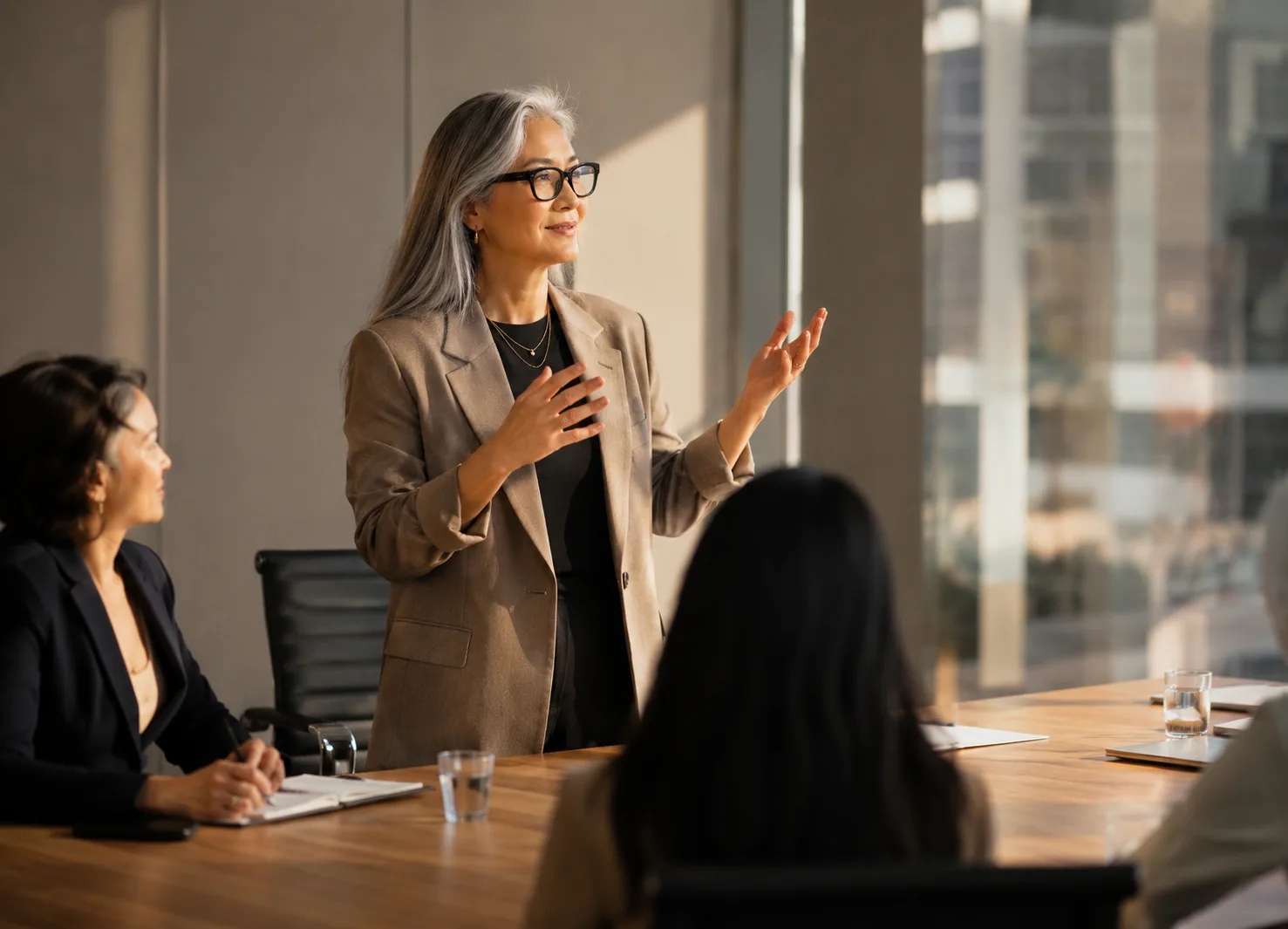 A woman with grey hair leading a discussion in an office