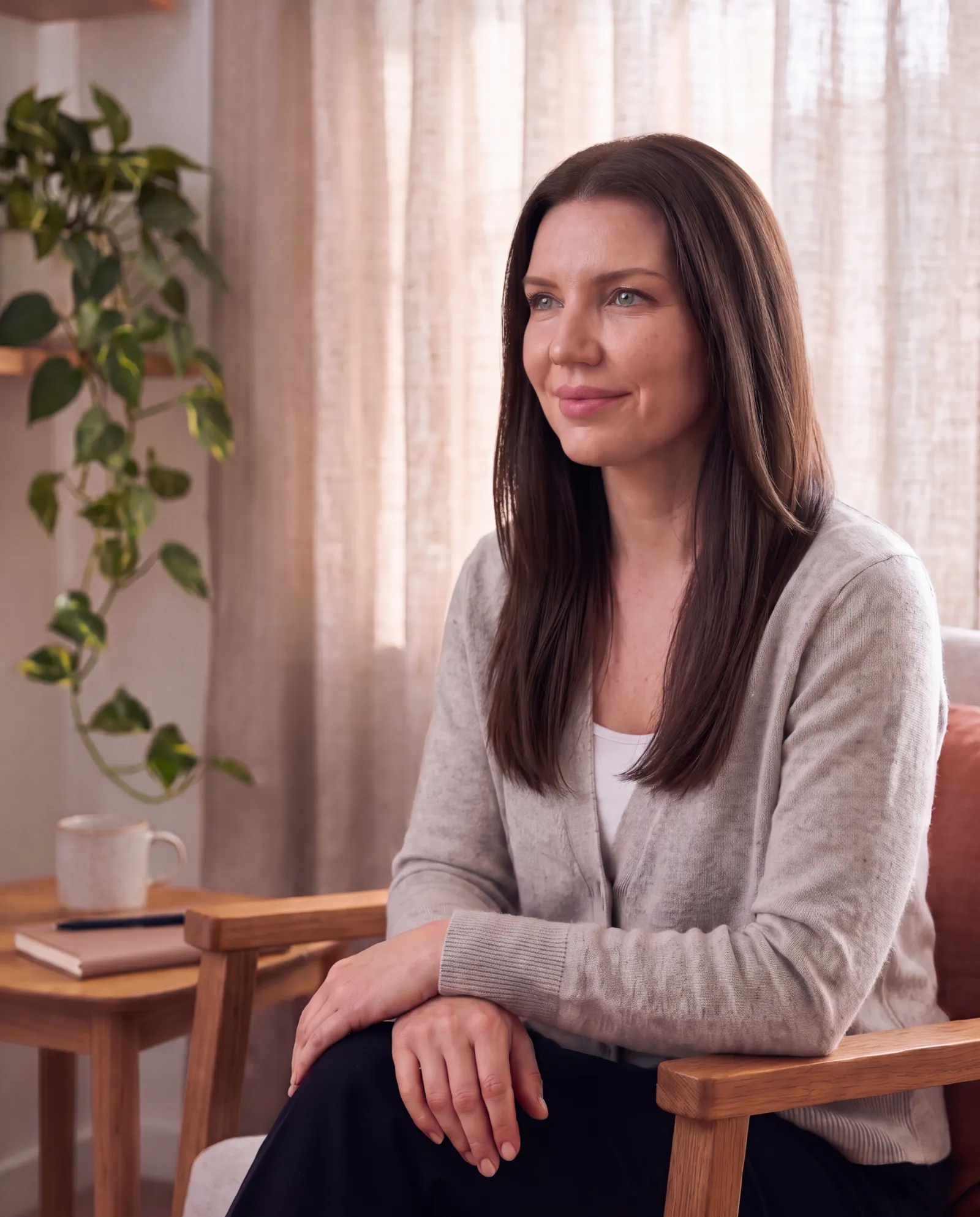 Jue Snell, psychotherapist, sitting in an armchair in her therapy room