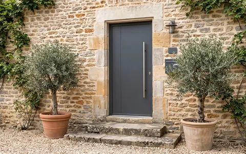 Porte d’entrée gris anthracite sur une façade en pierre