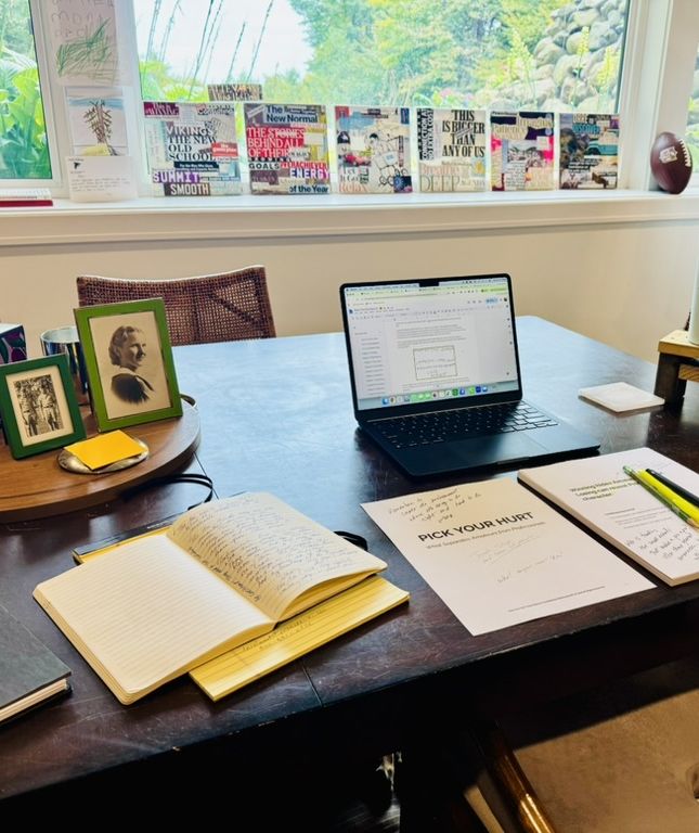 Ryan's desk with notebooks and the Pick Your Hurt manuscript