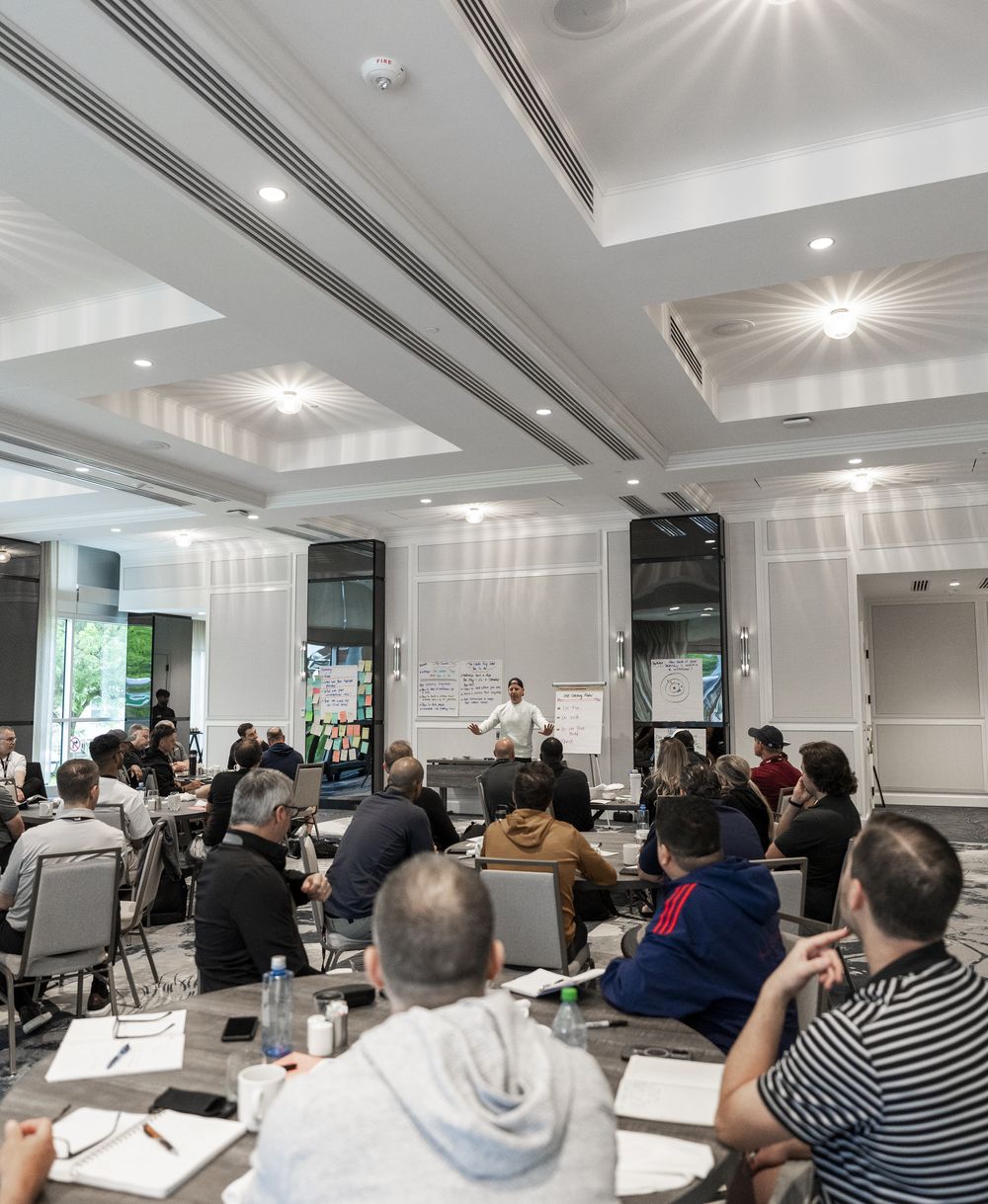 Ryan leading a workshop in a hotel ballroom