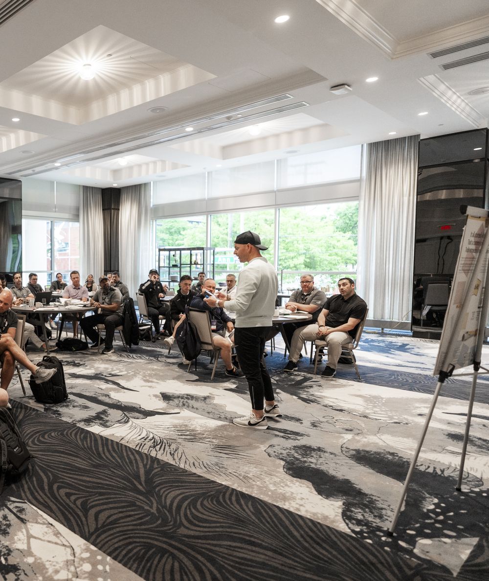 Ryan walking among tables during a coaches workshop