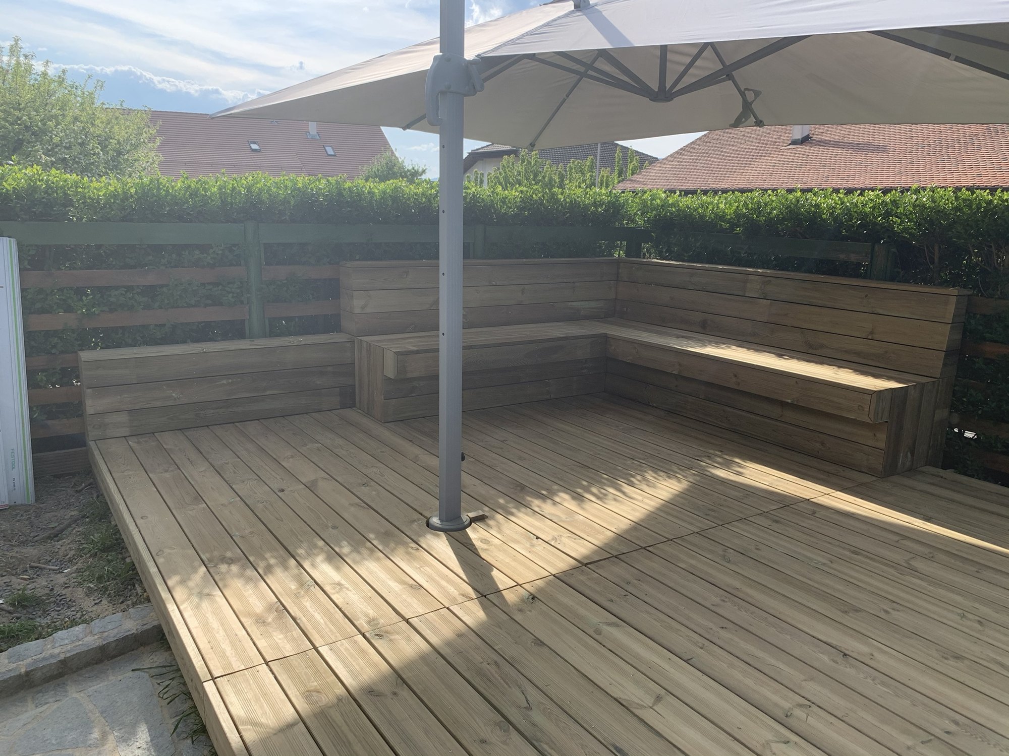 Terrasse en bois et banquettes d'angle à Corrobert