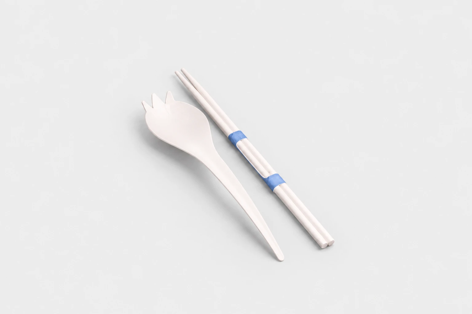 White spork beside bound chopsticks