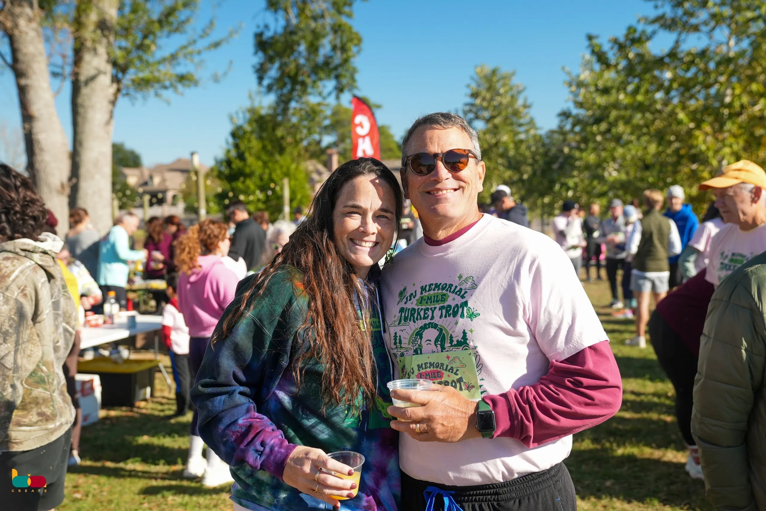 A couple in Turkey Trot shirts smiling at the post-race gathering