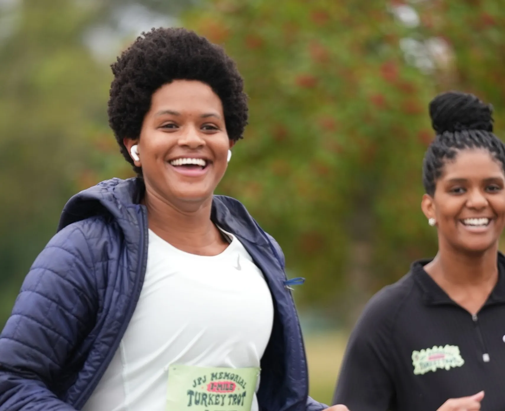Two women smiling as they run the course