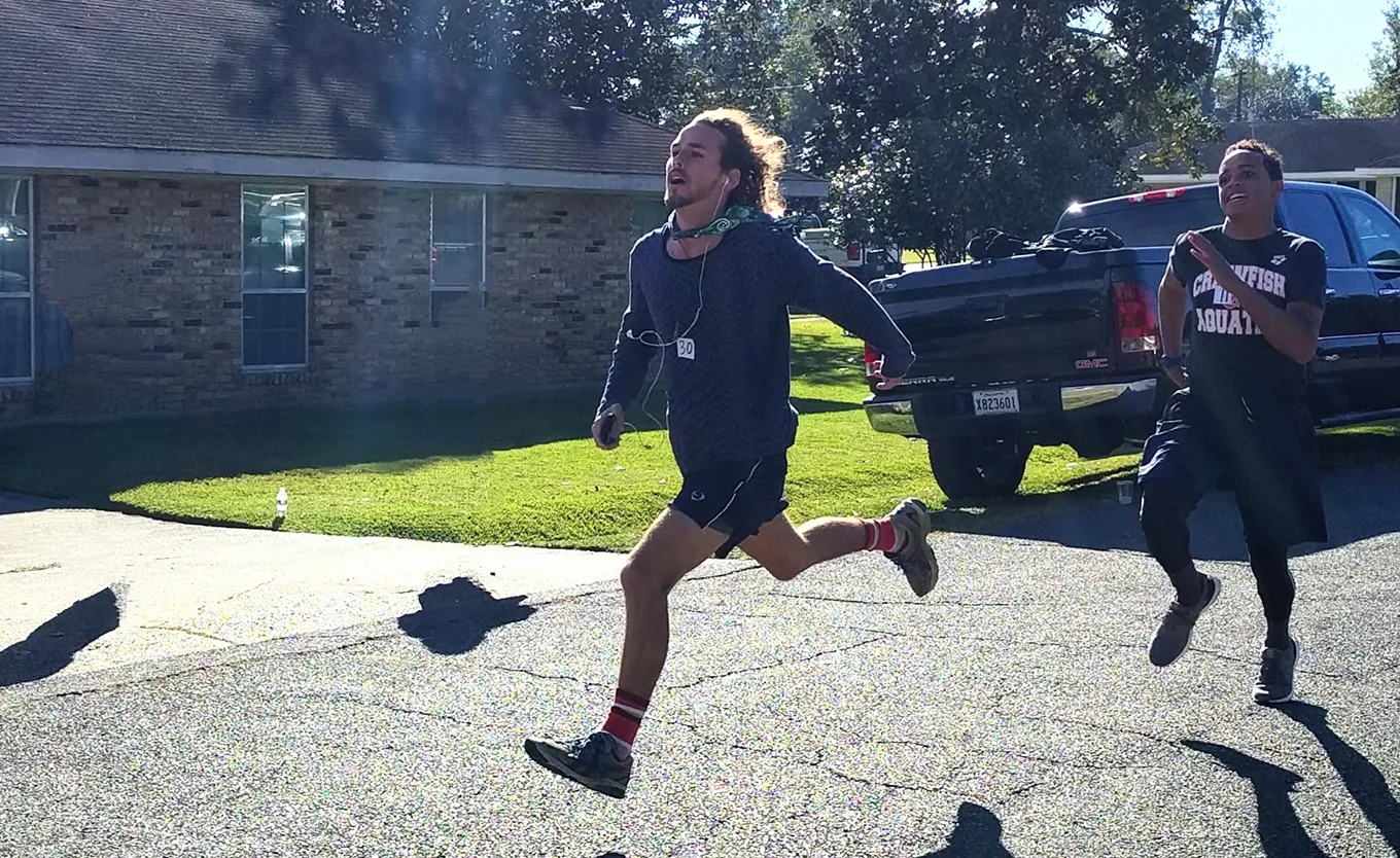 Runners racing down a neighborhood street on a sunny morning