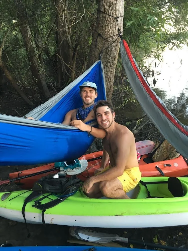 JeanPaul and a friend relaxing in hammocks and kayaks under the trees