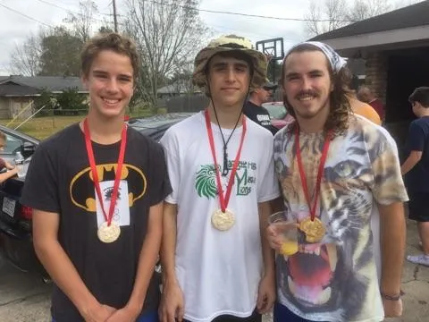 Three young men standing side by side wearing medals after the trot