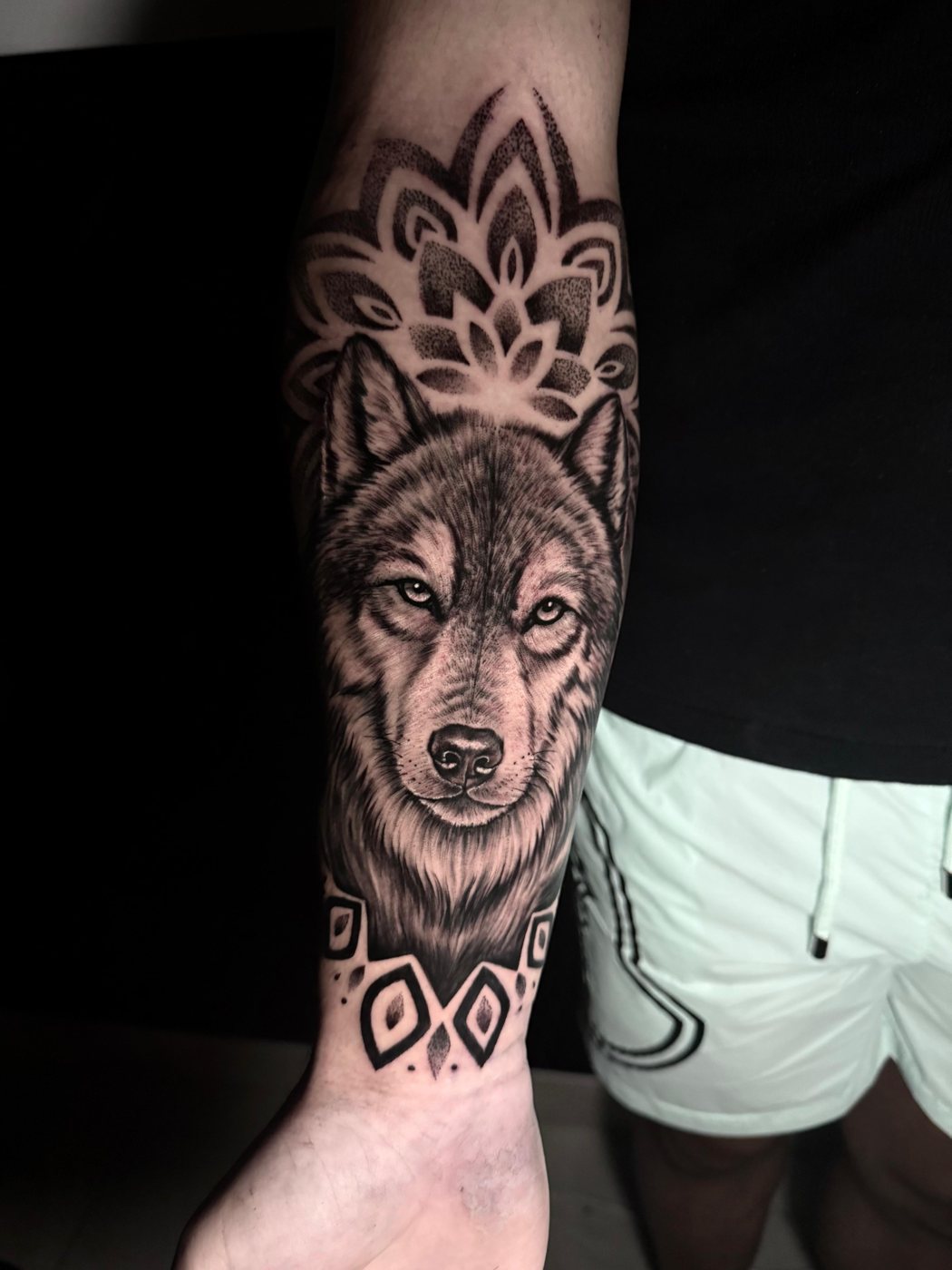 Black and grey realism wolf and mandala forearm tattoo by Valerio at Squires Ink, Surfers Paradise
