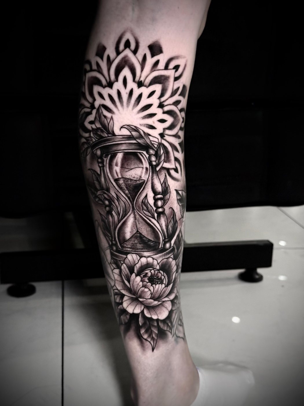 Black and grey hourglass, peony and mandala calf tattoo by Valerio at Squires Ink, Surfers Paradise