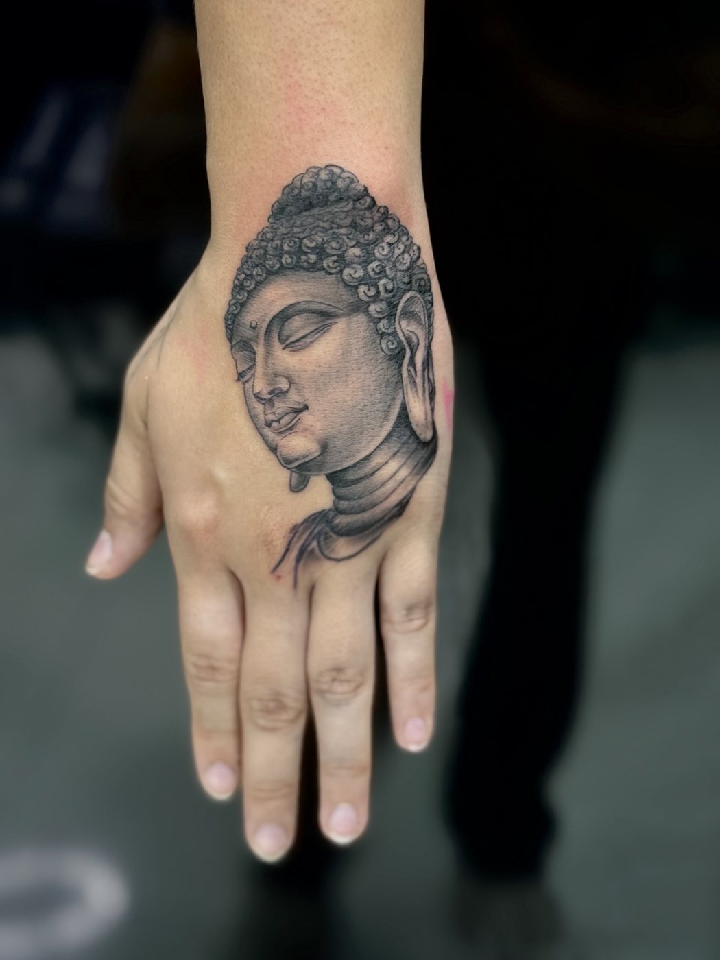 Micro realism Buddha tattoo on the hand by Santiago at Squires Ink, Surfers Paradise