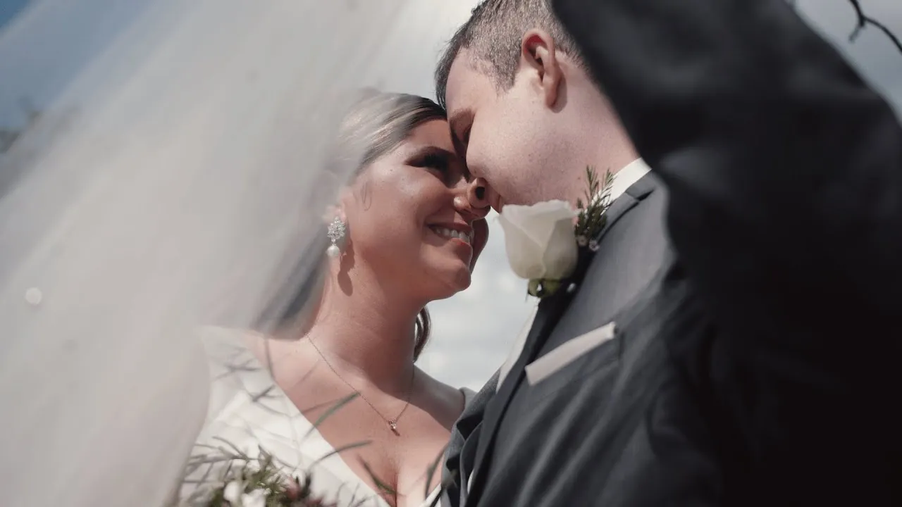 Lindsey and Jeremy forehead to forehead beneath her veil on their wedding day