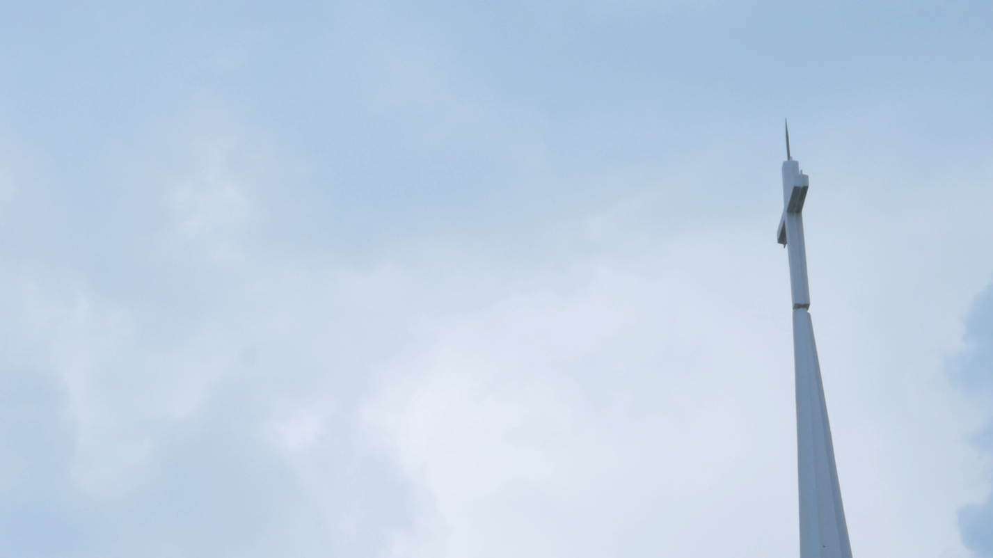 A white church steeple against a soft sky