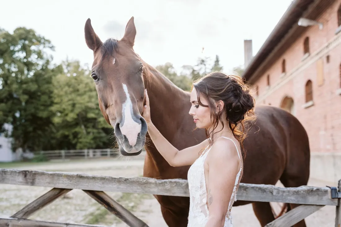 Braut streichelt ein Pferd in den Magical Homes