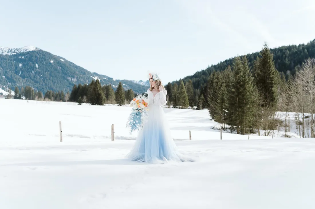 Braut im blauen Kleid im Schnee, Styled Shoot Hubertus