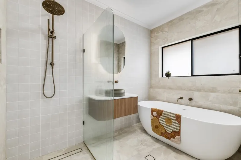 Bathroom wall and floor tiling in Bellevue Heights, with a freestanding bath and a floating timber vanity