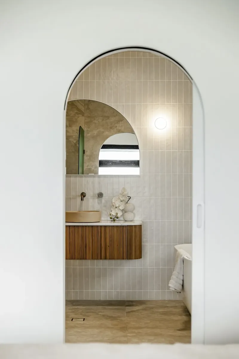 Tiled bathroom seen through an arched doorway in Bellevue Heights