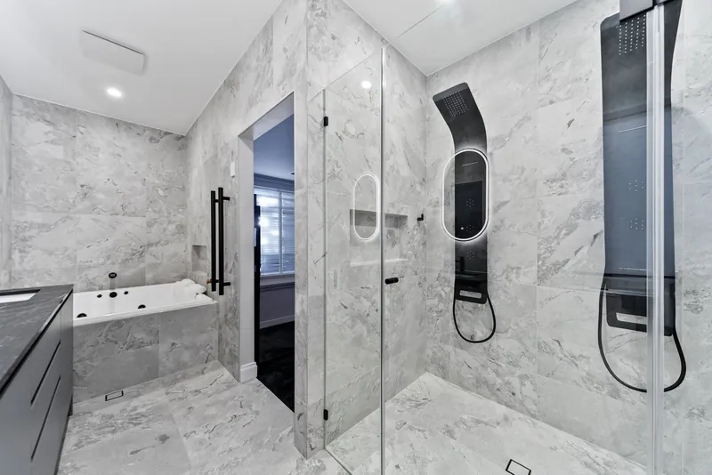 Bathroom wall and floor tiling in Craigburn Farm, with a bath and a glass shower